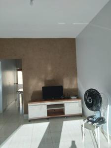 a living room with a desk with a tv and a chair at Casa primavera caldas novas in Caldas Novas