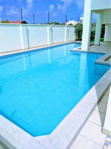 uma piscina com água azul num edifício em Modern 1bedroom 5 min walk to the beach near Severine Neptune beach resort behind go kart em Mombasa