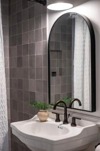 a bathroom with a sink and a mirror at The Ressman Haus at MarktPlatz with Hot Tub in Fredericksburg