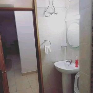uma casa de banho com um lavatório, um WC e um espelho. em Modern 1bedroom 5 min walk to the beach near Severine Neptune beach resort behind go kart em Mombasa
