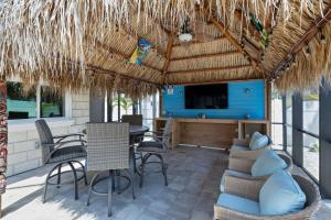 a patio with a table and chairs and a tv at Gorgeous Beach Condo with Pool Spa and Bikes in Fort Myers Beach