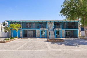 a blue building with a staircase in a parking lot at Gorgeous Beach Condo with Pool Spa and Bikes in Fort Myers Beach