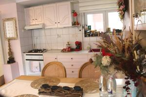 una cucina con tavolo in legno e un angolo cottura con frigorifero e piano cottura. di Central Park View Sinaia a Sinaia
