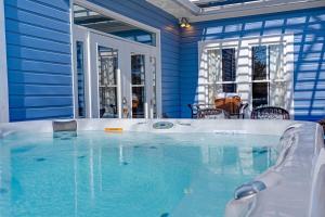 uma banheira de hidromassagem numa casa azul em Vino Vida spacious home with hot tub em Fredericksburg