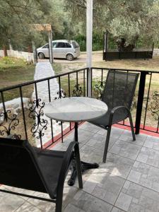 a table and a chair on a balcony at Helios Beach House in Mikros Gialos