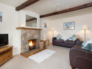 a living room with a fireplace and a couch at 2 Bed in Yanwath SZ085 in Penrith
