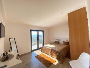a bedroom with a bed and a large window at Paraíso Céu Azul in Celorico de Basto