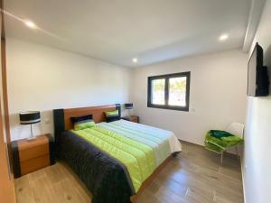 a bedroom with a bed with a green comforter and a window at Paraíso Céu Azul in Celorico de Basto +23 photos