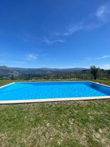 uma grande piscina azul num campo relvado em Paraíso Céu Azul em Celorico de Basto