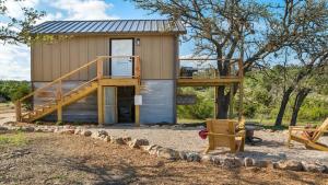 a tiny house with a deck and a porch at Jumping Goat Ranch-Treehouse Amazing View in Fredericksburg