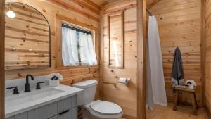 a log cabin bathroom with a toilet and a sink at Sweet Paradise cabin with private hot tub in Fredericksburg +40 photos
