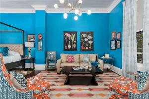 a living room with blue walls and a couch and chairs at The Loft on Main St loft with balcony views in Fredericksburg