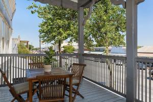 a porch with a table and chairs on a balcony at The Loft on Main St loft with balcony views in Fredericksburg