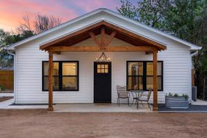 a small white house with a table and chairs at Getaway at Enchanted walk to Main Hot Tub in Fredericksburg