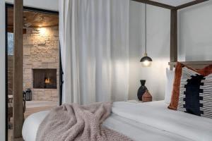 1 dormitorio con 1 cama grande y chimenea en Getaway at Enchanted walk to Main Hot Tub, en Fredericksburg