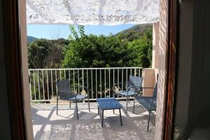 - un balcon avec des chaises et une table dans l'établissement Agréable villa - proche commodités mer et montagne, à Afa