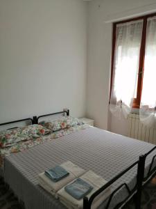 a bedroom with a bed with two towels on it at Appartamenti Fiumaretta MT 200 dalla spiaggia in Ameglia
