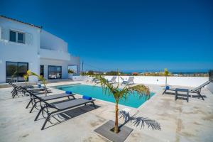a villa with a swimming pool and lounge chairs at Montis villa sea view heated pool in Daratso