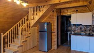 a kitchen with a refrigerator and a staircase at Horizon Racha in Ambrolauri