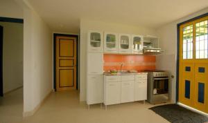 聖羅莎德卡瓦爾的住宿－Finca El Ovito，厨房配有白色橱柜和黄色门