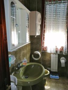 a bathroom with a green sink and a window at Appartamenti Fiumaretta MT 200 dalla spiaggia in Ameglia