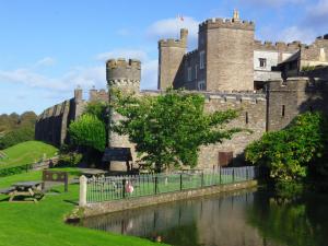un castillo con un río delante de él en Watermouth Castle, Harbour Apartment, en Ilfracombe