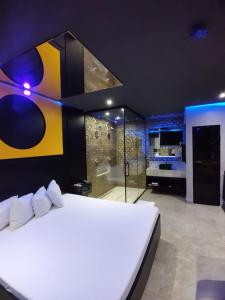 a bedroom with a large white bed and a bathroom at Motel Prestige in Sorocaba