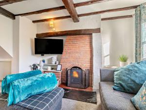 uma sala de estar com uma lareira de tijolos e um sofá em 5 Bed in Hoar Cross 94191 em Newborough