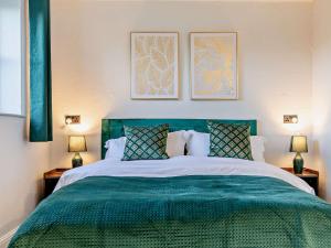 sypialnia z dużym zielonym łóżkiem z 2 lampami w obiekcie 5 Bed in Hoar Cross 94191 w mieście Newborough