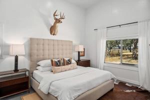 a bedroom with a bed with a deer head on the wall at Cactus Coterie with Hot tub & pet friendly in Fredericksburg