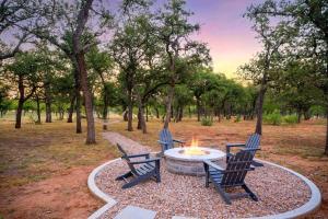 two chairs sitting around a fire pit in a park at Cactus Coterie with Hot tub & pet friendly in Fredericksburg