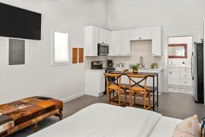 a kitchen with white cabinets and a table and chairs at Cactus Coterie with Hot tub & pet friendly in Fredericksburg