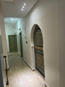 einen Flur mit Torbogen in einem Gebäude in der Unterkunft Hotel Transatlantique Tunis in Tunis