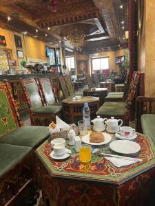 Hotel Transatlantique Tunis في تونس: غرفة طعام مع طاولة عليها طعام