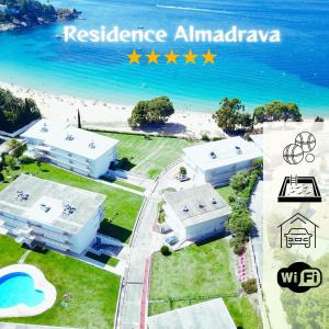 a view of two white buildings next to the beach at Almadrava Beach in Roses