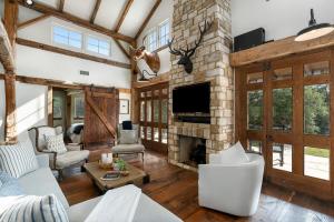a living room with a stone fireplace and a tv at River Hill Ranch, great views & river access! in Flugrath