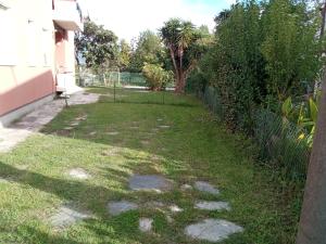 a yard with a fence and a grassy yard with a fence at Appartamenti Fiumaretta MT 200 dalla spiaggia in Ameglia