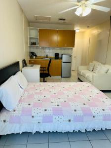 a bedroom with a pink and white bed and a kitchen at Hidden MIA Apartment in Miami