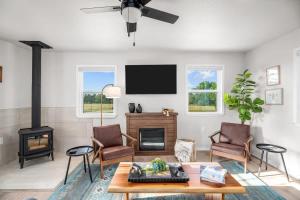 a living room with a fireplace and a flat screen tv at Cherry Pond with hot tub & spectacular VIEWS in Fredericksburg +29 photos