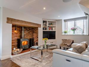 a living room with a fireplace and a couch at 1 Bed in Alderwasley 94394 in Alderwasley