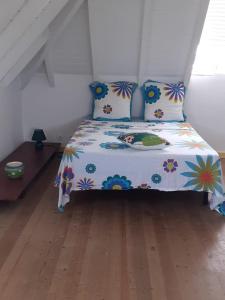a bedroom with a bed with a floral bedspread at Villa le vent du nord in Capesterre