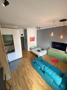 ein Wohnzimmer mit einem blauen Sofa und einem Bett in der Unterkunft 021 Hideout in Novi Sad