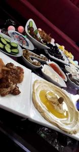 a table full of different types of food on plates at Petra bods inn in Amman