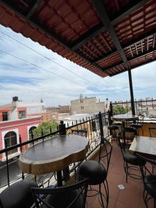 eine Terrasse mit Tischen und Stühlen auf dem Balkon in der Unterkunft Hotel La Casa de María Joyita in Aguascalientes