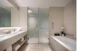 een witte badkamer met een bad en een douche bij Alma Resort in Thôn Mỹ Ca