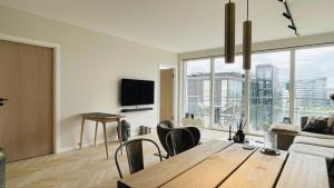 a living room with a wooden table and a large window at ApartmentInCopenhagen Apartment 1613 in Copenhagen