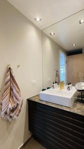 a bathroom with a sink and a large mirror at ApartmentInCopenhagen Apartment 1613 in Copenhagen