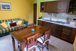 uma cozinha com uma mesa e uma cozinha com um sofá em Appartamento Talia em Bevagna