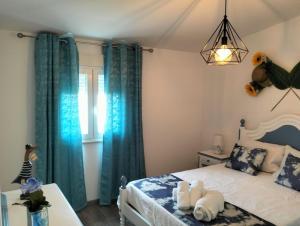 1 dormitorio con 1 cama con cortinas azules en Casa da Pitoquinha II en Casais do Rio