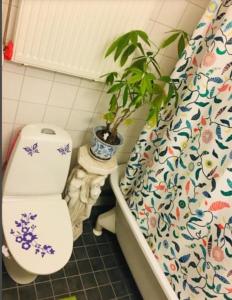 a bathroom with a toilet and a potted plant at Room at Stockholm - Sweden in Stockholm